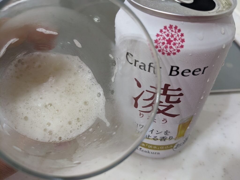 「クラフトビール凌（黄桜）」が入ったグラスを手前に傾けているところ