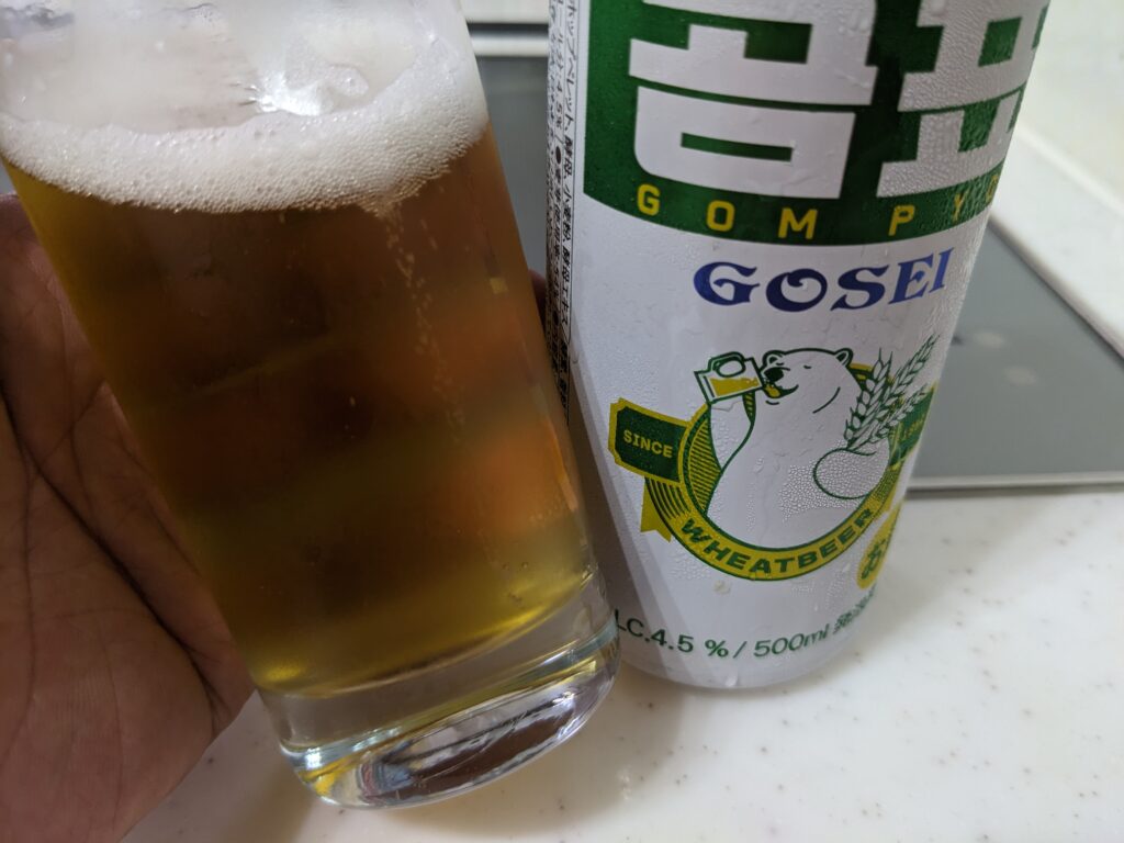 「GOSEI GOMPYO（ゴセイゴムピョ）ビール」が入ったグラスを手前に傾けているところ
