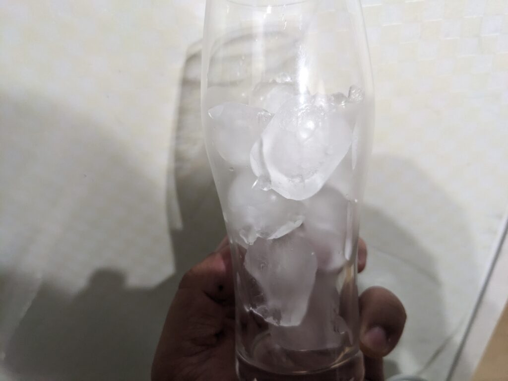 氷が入ったグラスを手で持っているところ