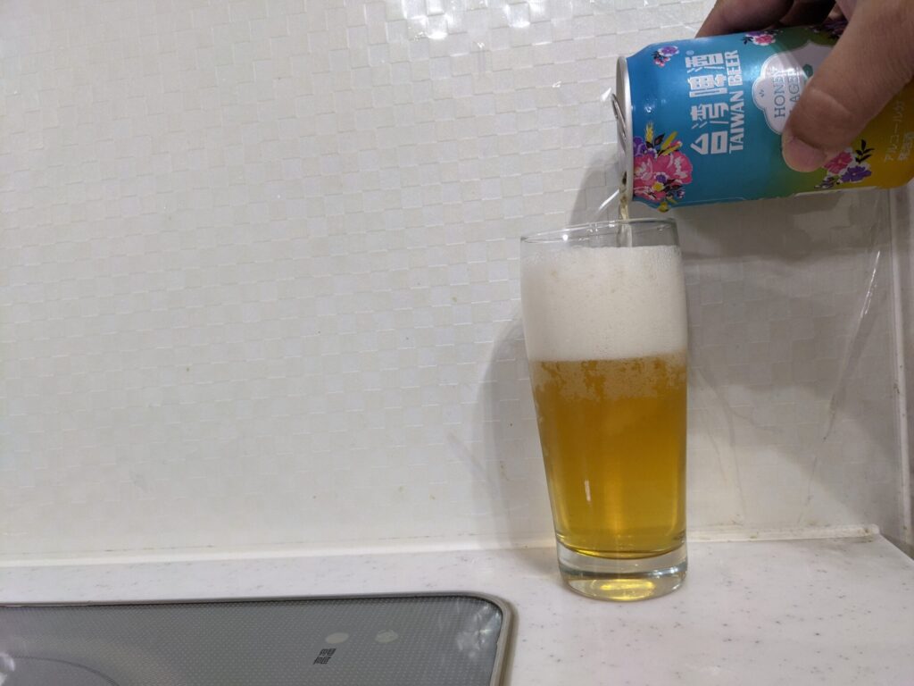 グラスに9割程の「台湾ビールハニーラガー」を注いでいる