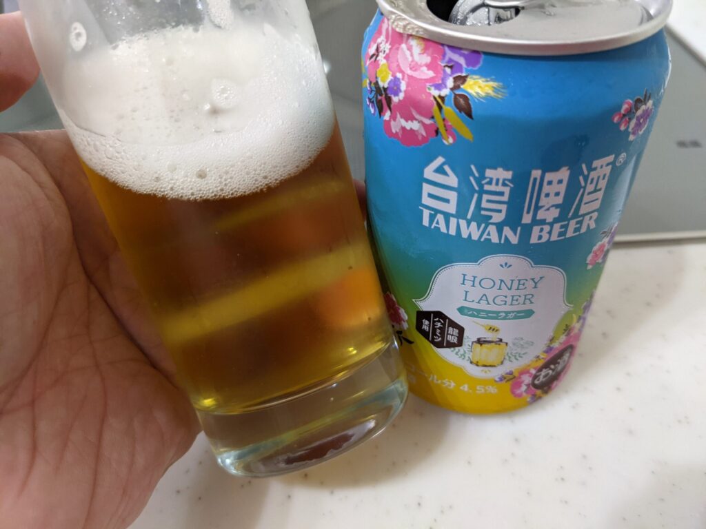 「台湾ビールハニーラガー」が入ったグラスを傾けている