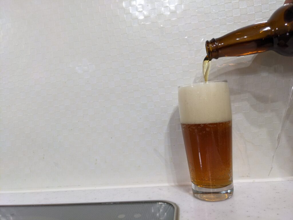 グラスに満タンの「日光いろはビール」を注いでいる