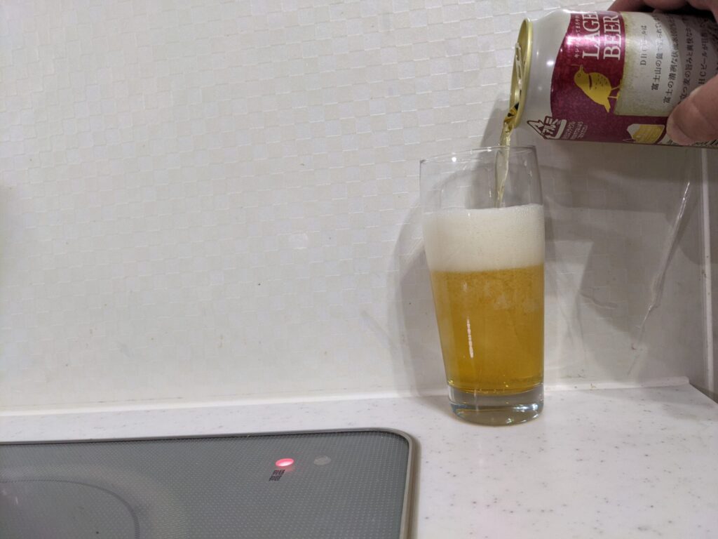 グラスに７割程の「DHCラガービール」を注いでいる