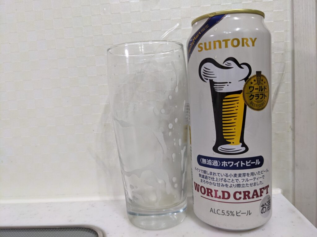 「ワールドクラフト無濾過ホワイトビール」を飲み終えたグラスとその空き缶