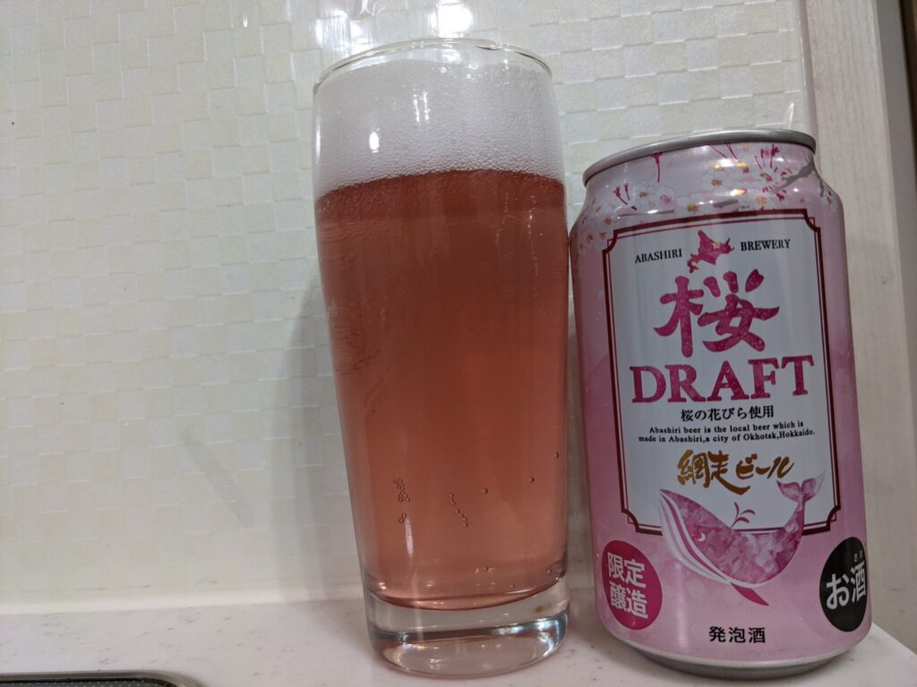 「網走ビール桜ドラフト」を注いだグラスとその缶