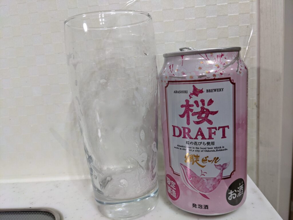 「網走ビール桜ドラフト」を飲み終えたグラスとその空き缶