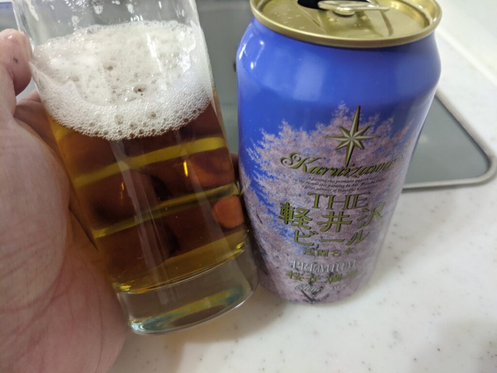 「軽井沢ビール桜花爛漫プレミアム」が入っているグラスを傾けているところ