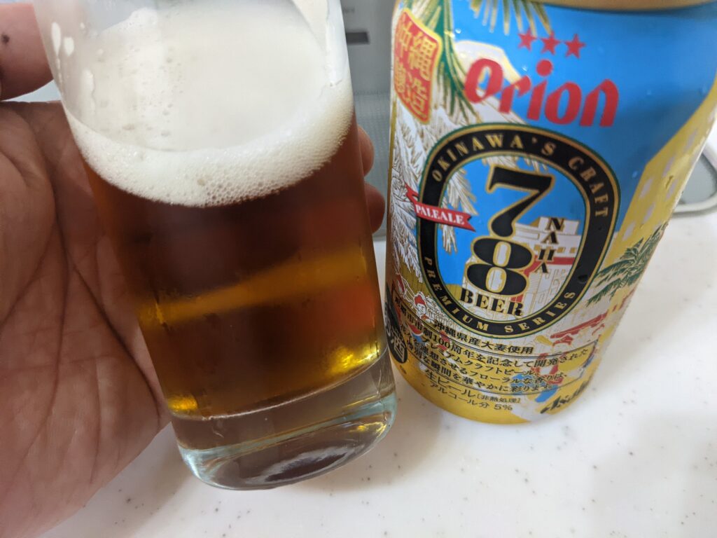 「78ビール（オリオン）」が入っているグラスを手で持っているところ