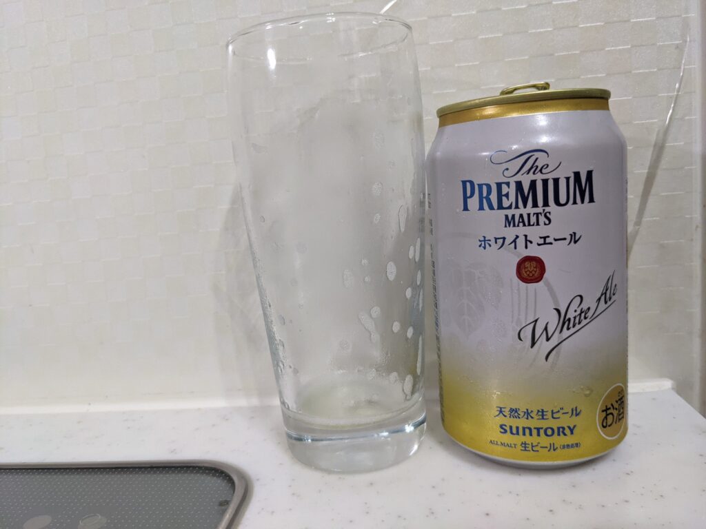 「プレモルホワイトエール」を飲み終えたグラスとその空き缶
