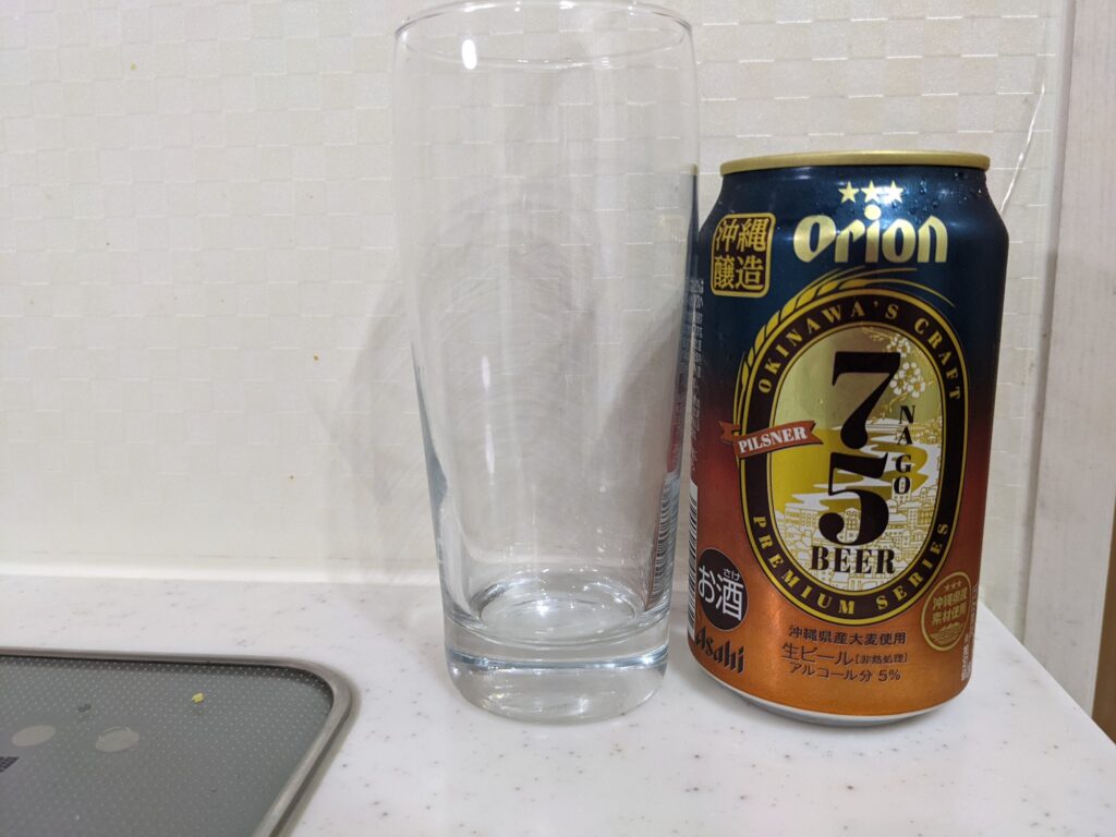 グラスと缶の「75（名護）ビールピスルナー」