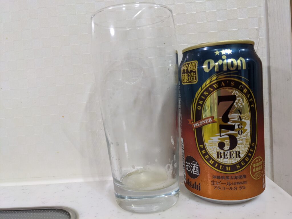 「75（名護）ビールピスルナー」を飲み終えたグラスとその空き缶