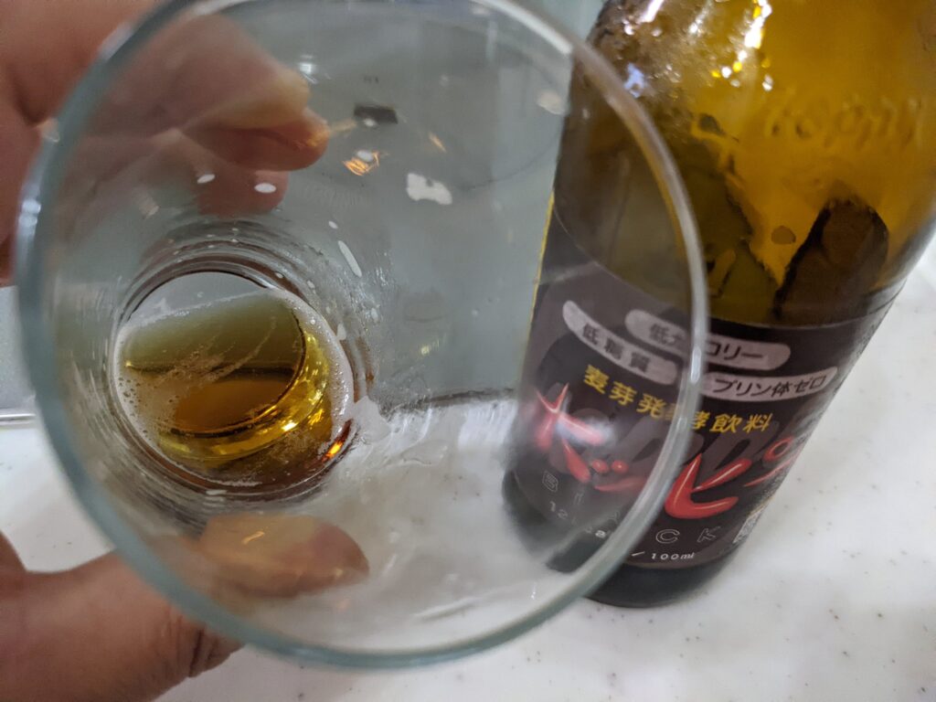 最後の一口程度のグラスに入った黒ホッピー（ホッピーブラック）