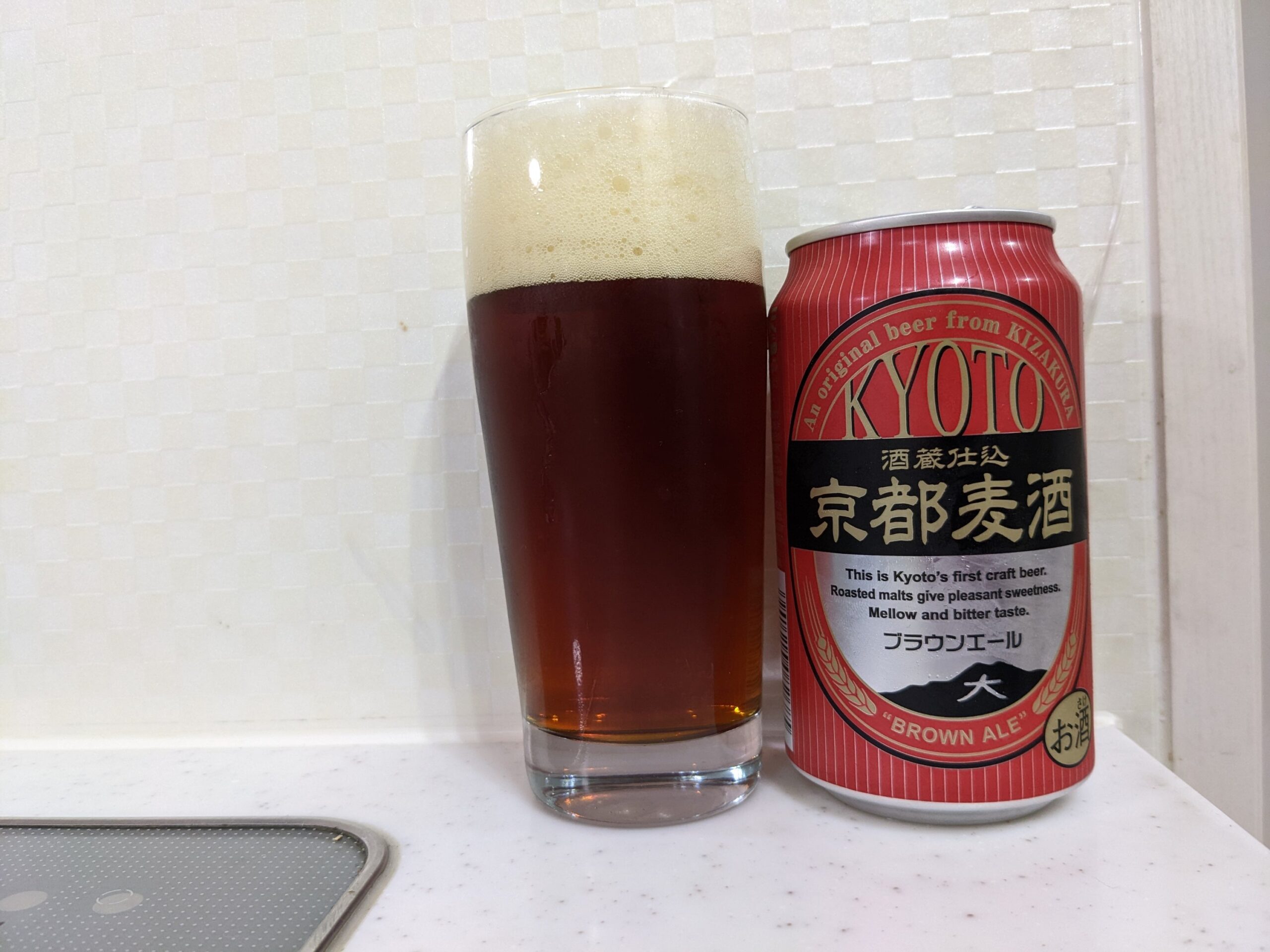「京都麦酒ブラウンエール 」が注がれたグラスとその缶
