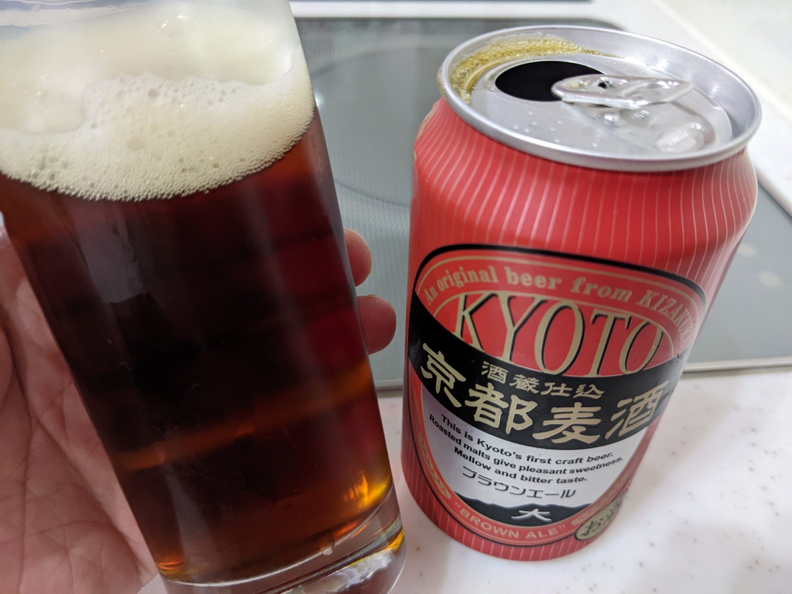 「京都麦酒ブラウンエール 」が入っているグラスを傾けているところ