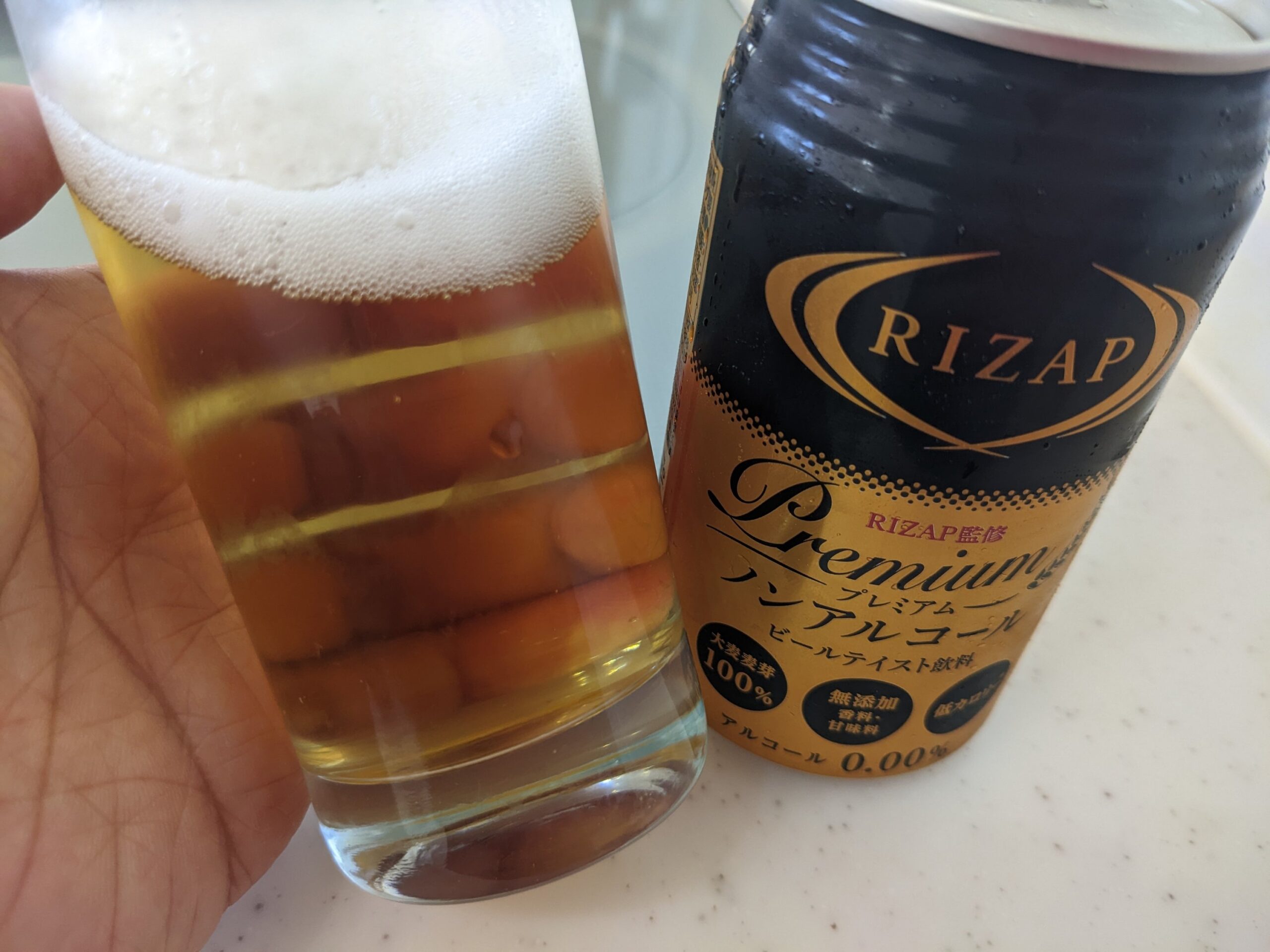 残り半分程のグラスに入った「RIZAP（ライザップ）プレミアムノンアルコールビールテイスト飲料」