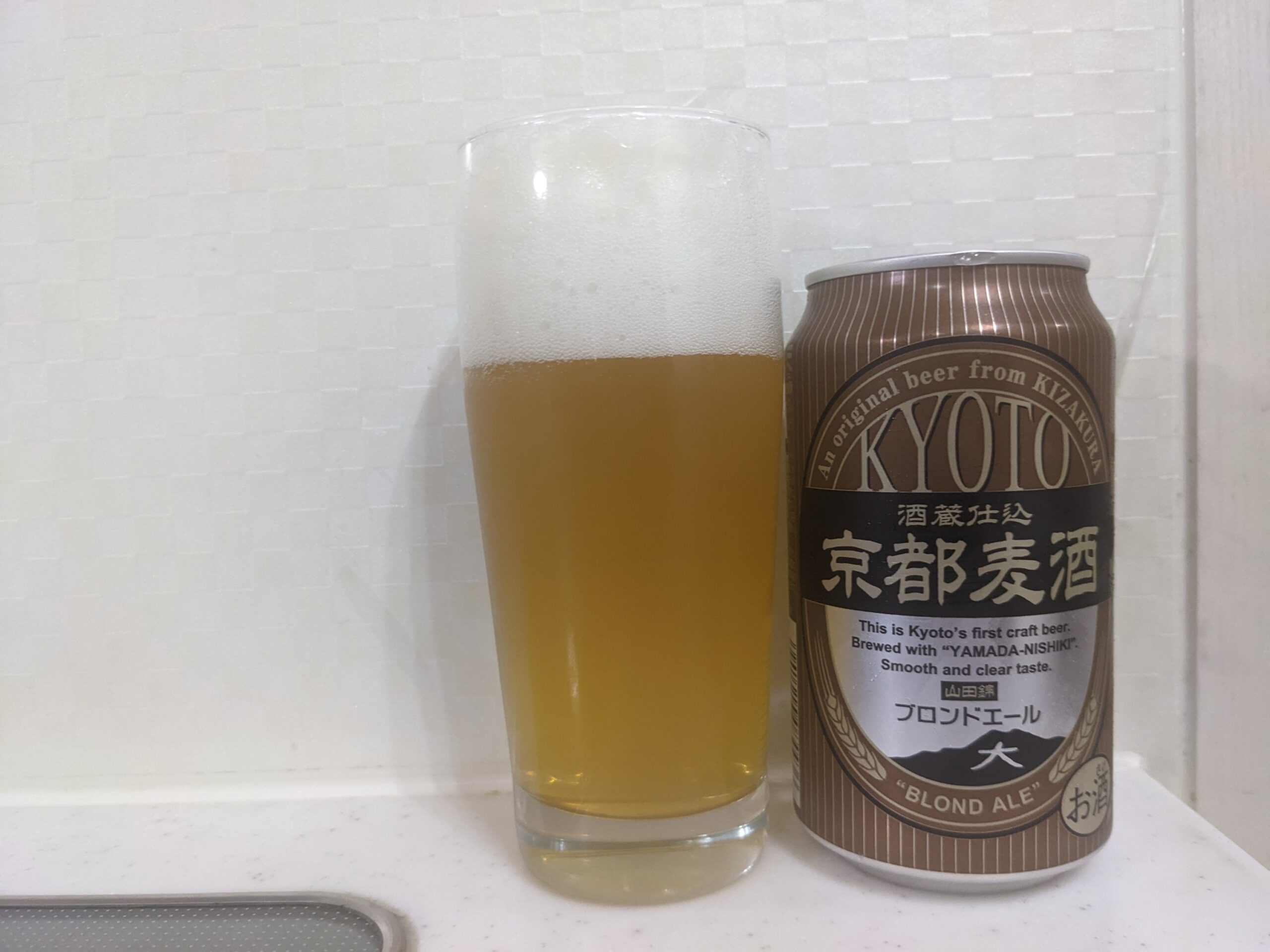 「京都麦酒ブロンドエール」が注がれたグラスとその缶