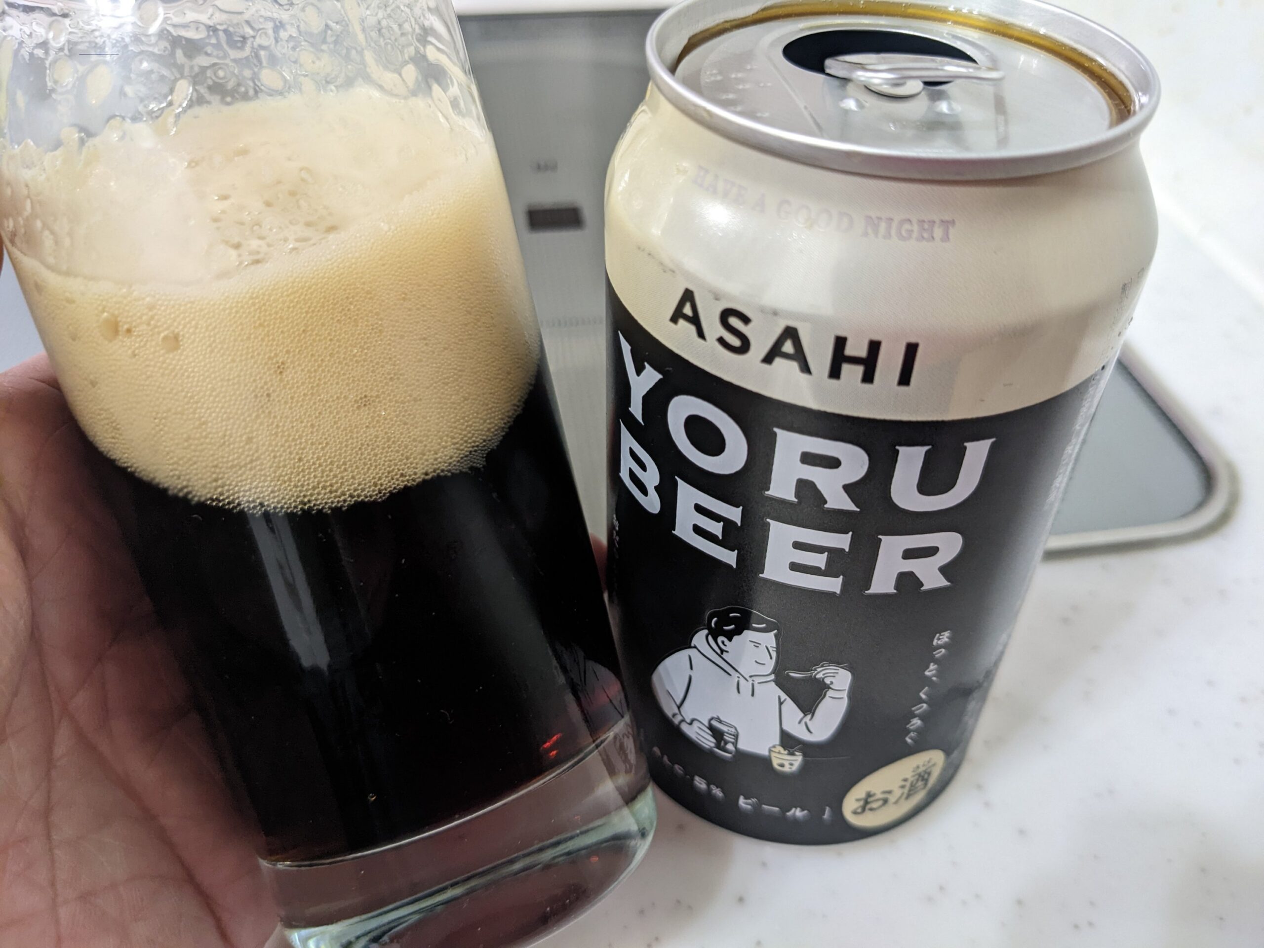 グラスに入ったアサヒ「YORU BEER（ヨルビール）」を傾けているところ